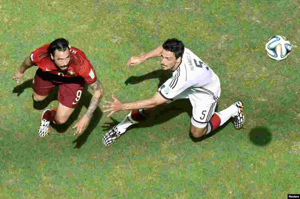 Portugal&#39;s Hugo Almeida fights for the ball with Germany&#39;s Mats Hummels during their 2014 World Cup Group G soccer match at the Fonte Nova arena in Salvador, June 16, 2014.