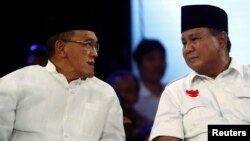 Ketua umum Partai Golkar Aburizal Bakrie dan kandidat presiden Prabowo Subianto dalam sebuah penampilan di televisi (9/7). (Reuters/Beawiharta)