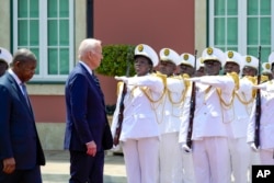 U.S. President Joe Biden inspects the honor guard with Angolan President Joao Lourenco at the Presidential Palace in the capital, Luanda, on Dec. 3, 2024.