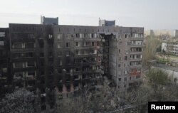 Sebuah bangunan tempat tinggal yang rusak akibat konflik Ukraina-Rusia di selatan kota pelabuhan Mariupol, Ukraina, 19 April 2022. (Foto: REUTERS/Pavel Klimov)