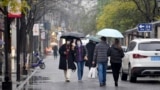 People wearing face masks to help protect against COVID-19 walk down an alley in Wuhan in central China's Hubei Province, Jan. 22, 2022. Sunday will mark two years since the city was placed under a 76-day lockdown as China tried to contain the first major