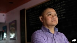 Sai Kyaw, an immigrant from Myanmar, stands in his Boston restaurant, Feb. 13, 2020. Kyaw said new travel restrictions are preventing his brother, sister and their families from joining him after nearly a dozen years in the visa application process.