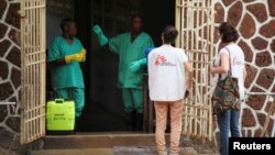 Dua petugas Dokter Tanpa Tapal Batas (MSF) berbicara dengan dua pekerja di Fasilitas Isolasi Pasien Ebola di Rumah Sakit Umum Mbandaka, Kongo. 