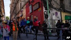 Mineros de oro descansan sobre una barricada policial durante una protesta en las calles de La Paz, Bolivia, el 25 de octubre de 2022.