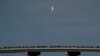 Los espectadores observan desde un puente en Titusville, Florida, mientras el SpaceX Falcon 9 despega con dos astronautas a bordo el 30 de mayo de 2020.