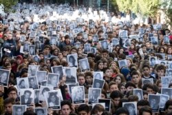 FILE - People hold up pictures of the victims of the 1994 bombing of the AMIA Jewish community center on the 21st anniversary of the terror attack in Buenos Aires, Argentina, July 17, 2015.