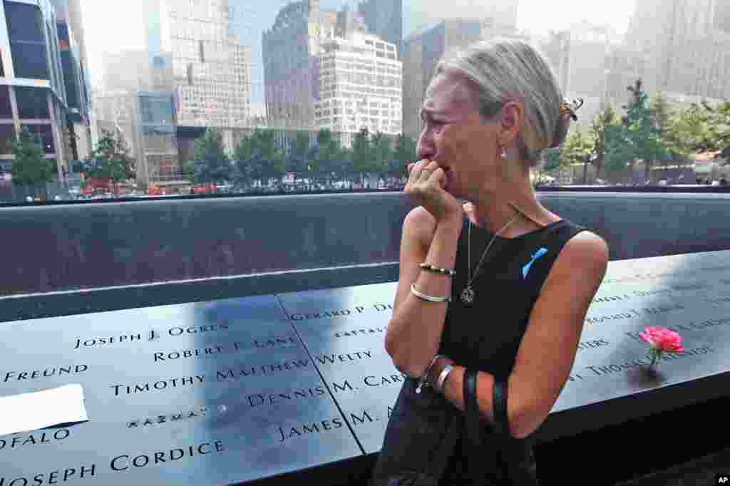Carrie Bergonia dari Pennsylvania menangis saat melihat nama tunangannya, petugas pemadam kebakaran Joseph Ogren, di Memorial 9/11 dalam upacara yang menandai 12 tahun serangan 11 September di World Trade Center, New York, 2013. (AP/Chris Pedota)