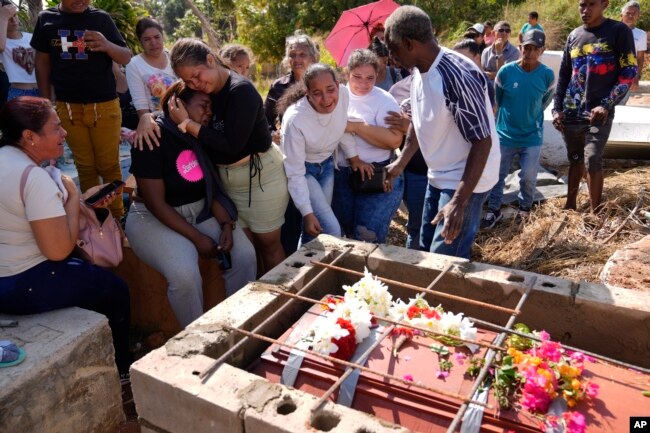 Familiares del minero Santiago Mora lloran durante su entierro en el cementerio de La Paragua, estado Bolívar, Venezuela, el jueves 22 de febrero de 2024. (Foto AP/Ariana Cubillos)