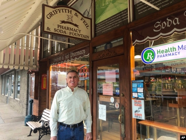 Ric Griffith appears outside of Griffith & Feil Pharmacy & Soda Fountain, a pharmacy he owns, on Jan. 15, 2021, in Kenova, W.Va. The pharmacy opened in 1892 with a soda fountain counter that was taken out in 1957 but reopened in 2004. (AP Photo/John Raby, File)