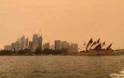 The haze from bushfires obscures the sun setting above the Sydney Opera House in Sydney, Dec. 6, 2019.