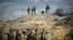 FILE - Members of Iran's Revolutionary guard monitor an area as they stand on a hill top in the Hormuz area of southern Iran, April 24, 2010. 