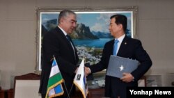 한민구 한국 국방장관과 카불 베르디에프 우즈베키스탄 국방장관이 21일 오후 서울 국방부에서 양국 간 군사교육 부문의 협력을 확대하기 위한 양해각서에 서명한 후 악수하고 있다. 