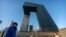 FILE- In this Thursday, Feb. 4, 2021 file photo, people wearing face masks to protect against the spread of the coronavirus, walk past the CCTV Headquarters building, the home of Chinese state-run television network CCTV and its overseas arm CGTN,…
