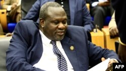 South Sudan's opposition leader Riek Machar reads documents in Khartoum, Aug. 30, 2018, as Sudanese and South-Sudanese leaders signed a deal to end their civil war.