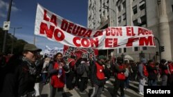 Manifestantes sostienen un cartel que reza: "La deuda es con el pueblo con con el FMI", durante una protesta en Buenos Aires, el 4 de septiembre de 2019.