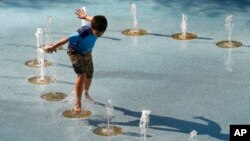 La gente aprovecha las fuentes en Phoenix, Arizona, para refrescarse ante el intenso calor.