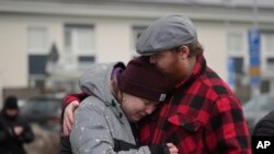 People gather at a makeshift memorial near the site of a shooting in Orebro, Sweden.