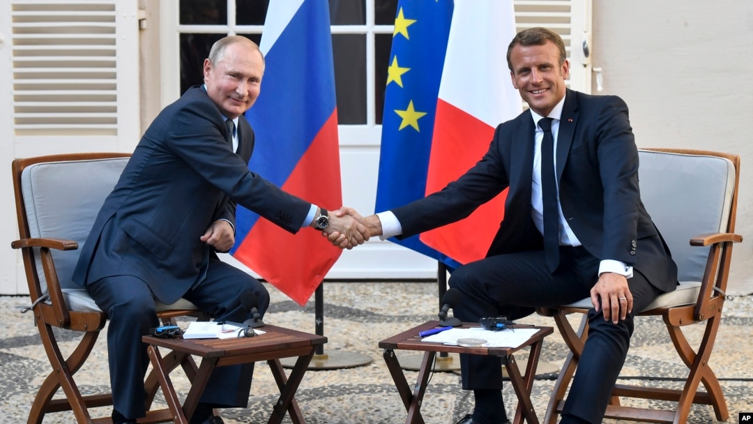 French President Emmanuel Macron, right, shakes hands with Russian President Vladimir Putin after their meeting at the fort of Bregancon in Bormes-les-Mimosas, southern France, Aug. 19, 2019. 