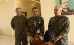 FILE - SDF general commander Mazloum Abdi, center, speaks during a press conference in Kobani, Syria, July 22, 2019. (S. Kajjo/VOA video grab)