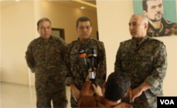 FILE - SDF general commander Mazloum Abdi, center, speaks during a press conference in Kobani, Syria, July 22, 2019. (S. Kajjo/VOA video grab)