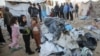 Palestinians inspect the damage at a tent camp sheltering displaced people, following an Israeli strike, in Khan Younis, southern Gaza Strip