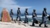 Soldiers of China's People's Liberation Army (PLA) Navy patrol Woody Island in the Paracel archipelago on January 29, 2016.