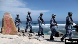 Soldiers of China's People's Liberation Army (PLA) Navy patrol Woody Island in the Paracel archipelago on January 29, 2016.