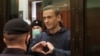 El opositor ruso Alexei Navalny hace un gesto a sus familiares durante una audiencia en una corte de Moscú. [Foto de archivo]