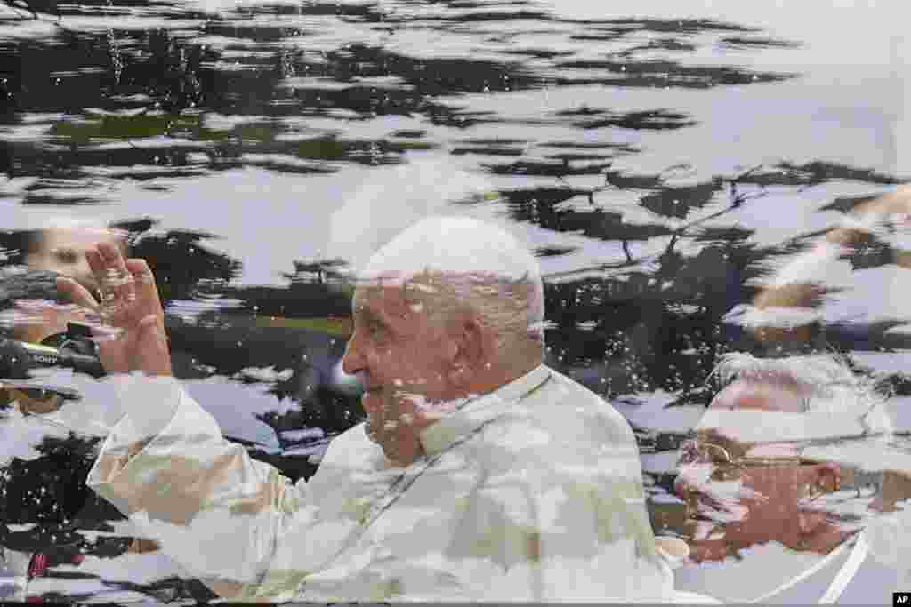 Pope Francis waves from a pope mobile at the Cercle-Cite convention center in Luxembourg after a meeting with the national authorities and the civil society on the first day of Francis&#39;s four-day visit to Luxembourg and Belgium.