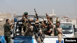 FILE - Houthi troops ride on the back of a police patrol truck in Sanaa, Yemen, Feb. 19, 2020. 