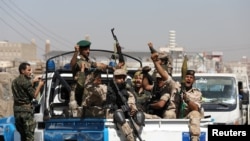 FILE - Houthi troops ride on the back of a police patrol truck after participating in a Houthi gathering in Sana'a, Yemen, Feb. 19, 2020.