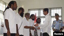 This Antara Foto photo shows Indonesia's President Joko Widodo shaking hands with and officially pardoning five political prisoners during a ceremony at a prison in Jayapura, Papua province, May 9, 2015.