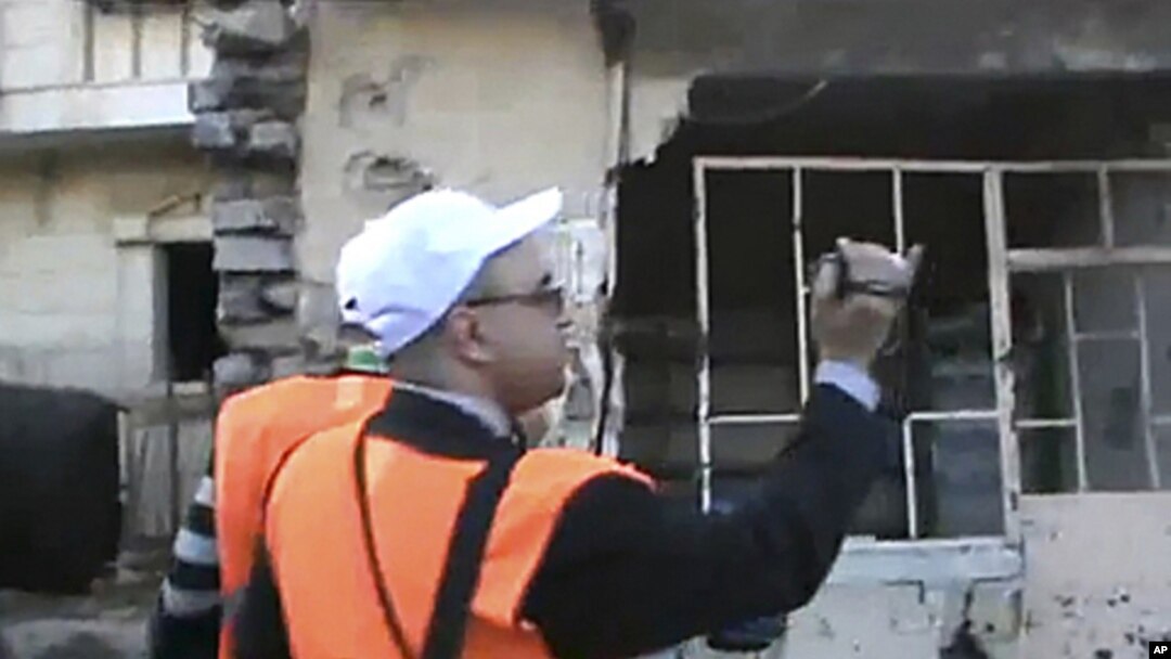 In this image made from amateur video released by Shaam News Network purports to show Arab League monitors visiting the Baba Amr area of Homs in Syria, December 28, 2011. (AP cannot independently verify the content, date, location or authenticity of this 