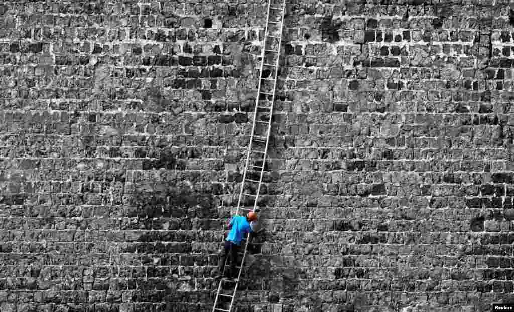 A worker cleans a wall at the Jaffna Fort, a fort built by the Portuguese in 1618, in Jaffna, Sri Lanka.