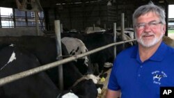 Dave Daniels stands in front of some of his 575 dairy cows on his farm in Union Grove, Wis., Aug. 6, 2019. 