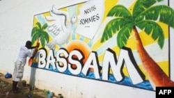 Un homme peint un mur dans le cadre du Festival international du dessin animé et de la bande dessinée d'Abidjan de Coco Bulles, en hommage aux victimes de l'attaque de 2016 à Grand-Bassam, le 18 mars 2017.