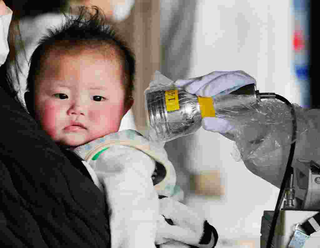 Warga Tokyo diperingatkan untuk tidak memberikan minuman dari ledeng untuk bayi, karena tercemar radiasi dari pusat nuklir akibat gempa bumi dan tsunami. Bayi ini sedang diperiksa di kota Fukushima, 24 Maret 2011 (Reuters/Kyodo)