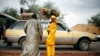 Une famille malienne attend un taxi à un barrage sur la route Gao à l'extérieur de Sévaré , à 620 kilomètres au nord de la capitale du Mali Bamako, le 27 Janvier 2013.