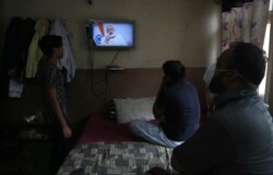 People in Hyderabad, India watch Prime Minister Narendra Modi address the nation in a televised speech about COVID-19 situation, Tuesday, April 14, 2020.