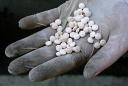 FILE - A Bulgarian customs officer displays Captagon pills confiscated in Sofia, Dec. 12, 2007.