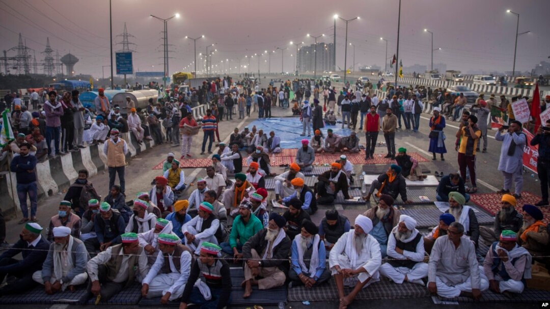 Para petani mendengarkan pembicara di tengah jalan tol di lokasi protes terhadap undang-undang pertanian baru di perbatasan negara bagian Delhi-Uttar Pradesh, India, Sabtu, 5 Desember 2020. (Foto: dok).