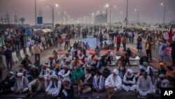 Para petani mendengarkan pembicara di tengah jalan tol di lokasi protes terhadap undang-undang pertanian baru di perbatasan negara bagian Delhi-Uttar Pradesh, India, Sabtu, 5 Desember 2020. (Foto: dok).