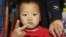 FILE - A young Chinese boy poses as he and a group of children that were recently rescued from child traffickers. Police in China have broken a child trafficking ring that they say had been selling children from the remote southwest to buyers near the coast for as little as about $3,000.