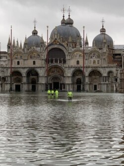 FILE - Emergency workers are seen wading through high waters during November flooding in Venice. (Sabina Castelfranco/VOA)
