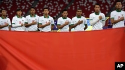 Tim sepak bola Indonesia menyanyikan lagu kebangsaan mereka menjelang pertandingan mereka melawan Vietnam untuk medali perunggu pada SEA Games di Singapura, Senin, 15 Juni 2015. (Foto: AP)