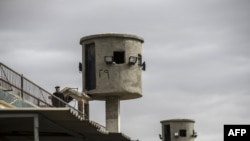 A picture taken during a guided tour organized by Egypt's State Information Service on Feb. 11, 2020, shows an Egyptian policeman near watch towers at Tora prison in the Egyptian capital Cairo.