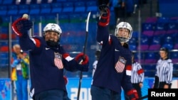 Megan Bozek (izquierda) y Kacey Bellamy celebran el triunfo en la semifinal de hockey para mujeres en Sochi 2014.