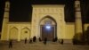 FILE - Men stand outside the Id Kah Mosque before morning prayers in Kashgar, Xinjiang Uighur Autonomous Region, China, March 23, 2017. 