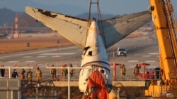 Sebuah derek mengangkat bagian ekor pesawat selama operasi penyelamatan pesawat Boeing 737-800 Jeju Air yang jatuh dan terbakar pada 29 Desember 2024 di Bandara Internasional Muan, Muan pada 3 Januari 2025. (Foto: AFP)