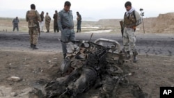 Afghan security forces gather at the site of Monday's suicide attack near the Bagram Air Base, north of Kabul, Afghanistan, April 9, 2019. 